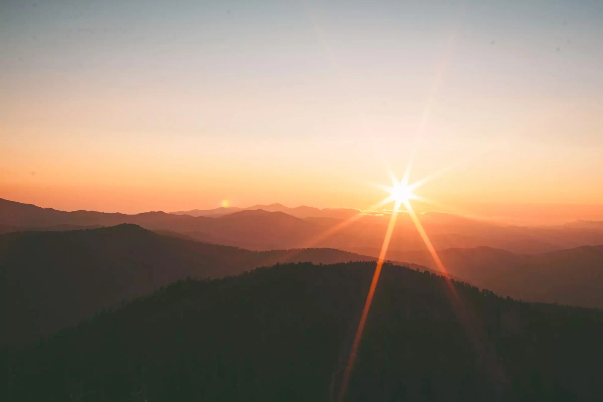 Un coucher de soleil par dessus des collines