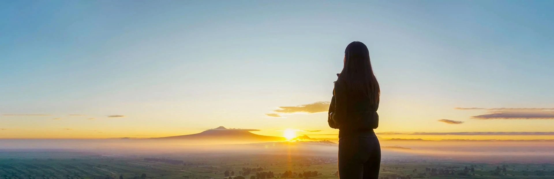 Une femme regarde un coucher de soleil