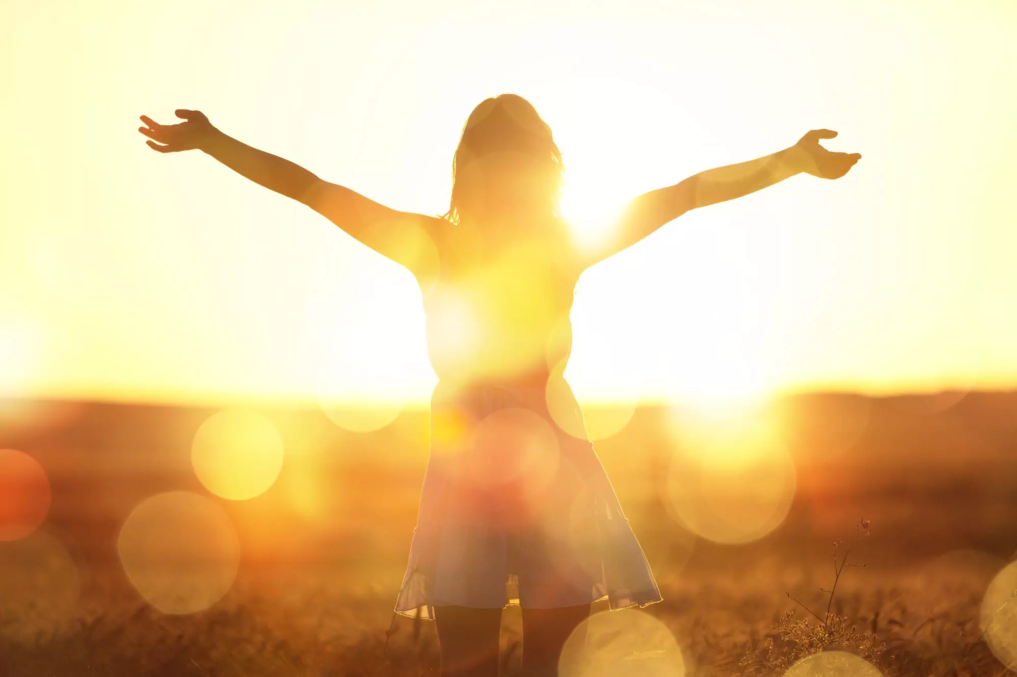 Une femme face à un coucher de soleil