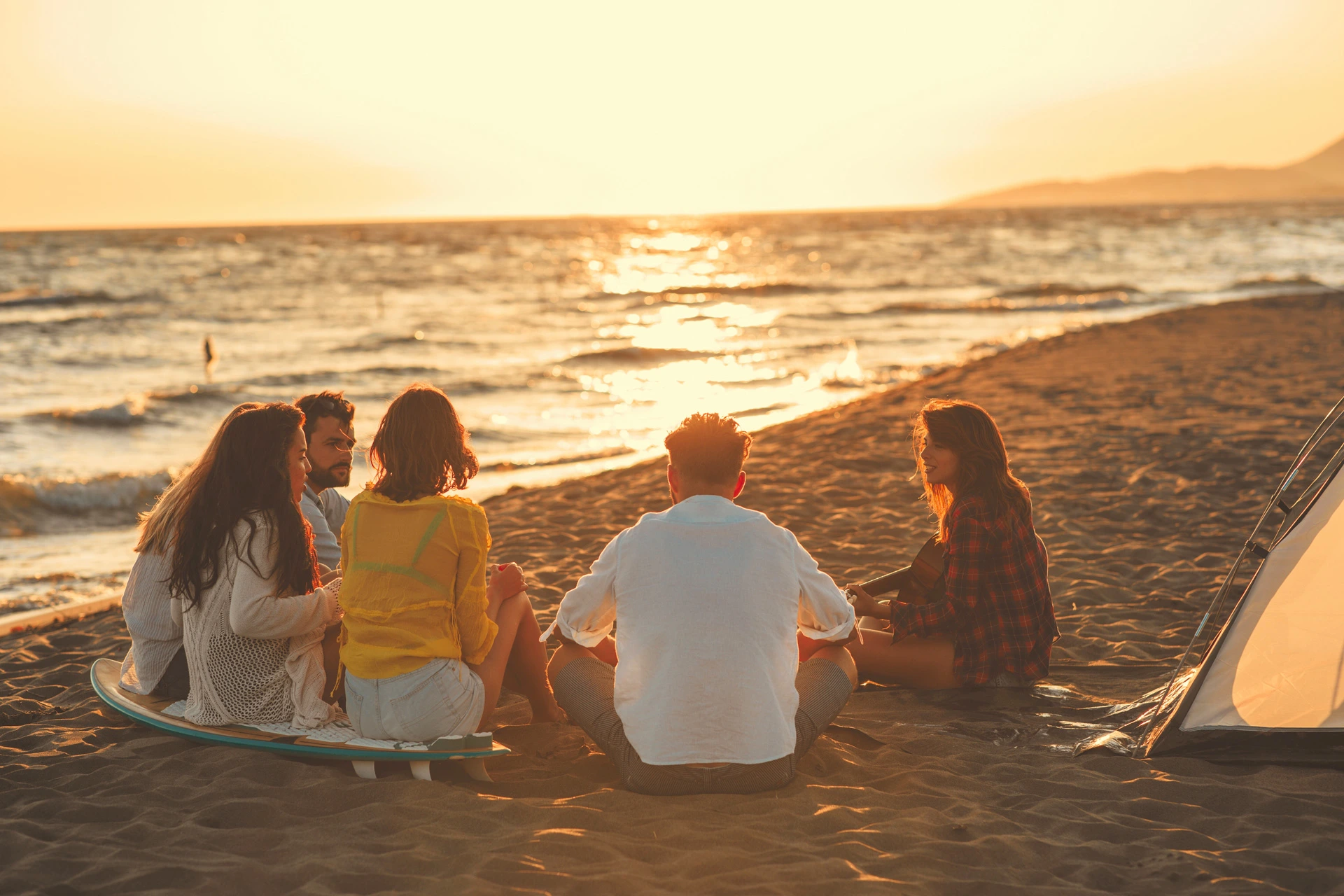 Des amis à plage face au coucher de soleil